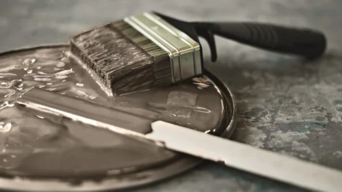 Malerpensel på låg fra malerbøtte