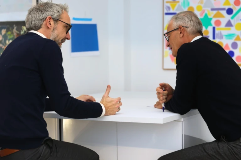Two colleagues in conversation at a table.