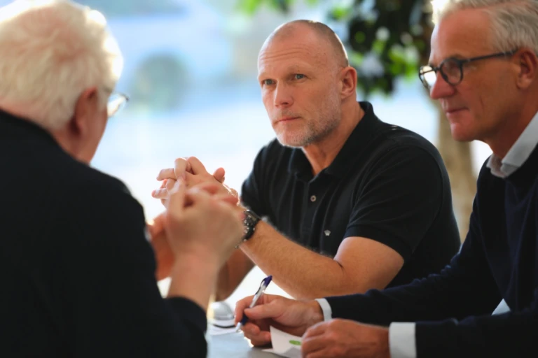 Meeting at a table with three colleagues in discussion.